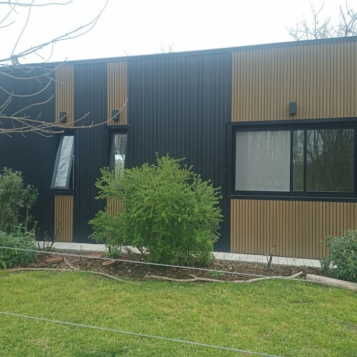 Casa con carpintería de aluminio negro y grandes paños vidriados
