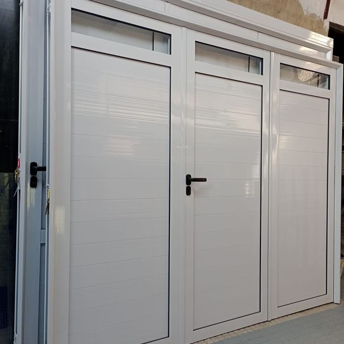 Portón de aluminio blanco de 3 hojas con paños vidriados superiores