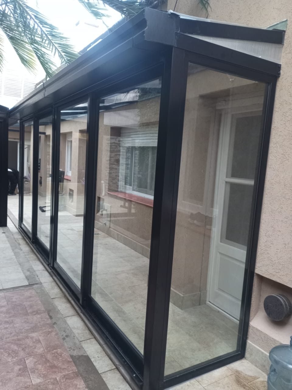 Techo de policarbonato con estructura de aluminio sobre cerramiento vidriado