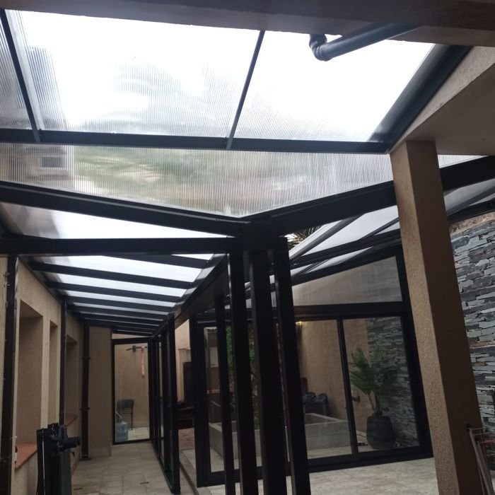 Techo de policarbonato sobre patio interno con estructura de aluminio