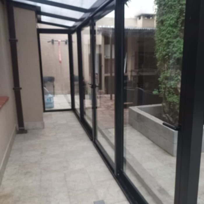 Cerramiento vidriado de patio con estructura de aluminio negro