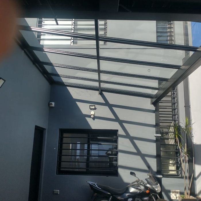 Detalle de techo de vidrio laminado con guía de aluminio