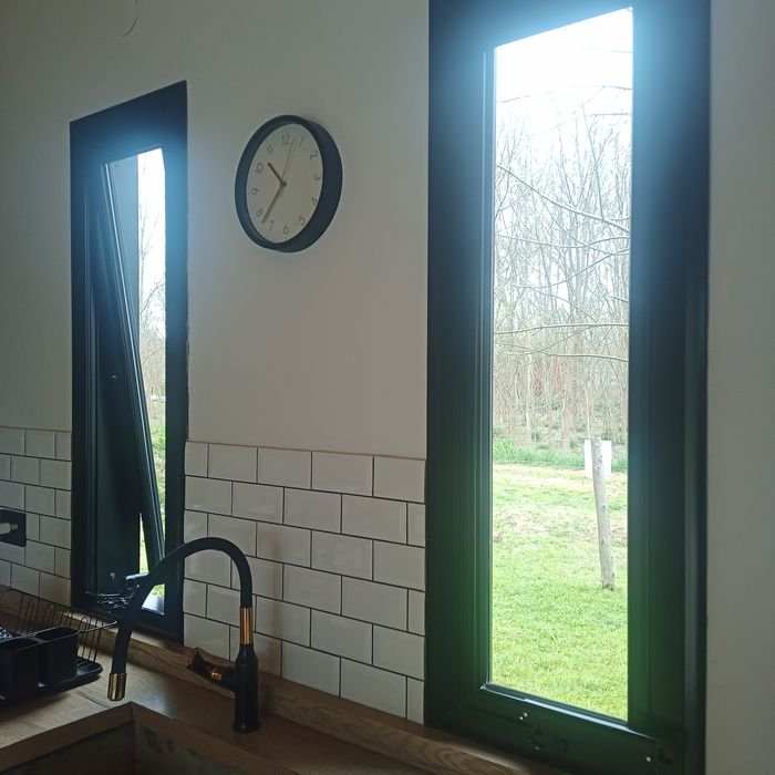 Ventana proyectante de aluminio negro sobre bacha de cocina